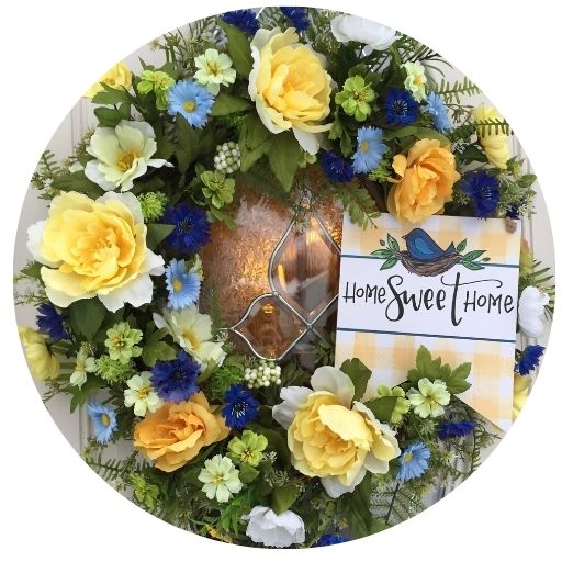 Yellow, blue and green flowers on a grapevine wreath with text Home Sweet Home
